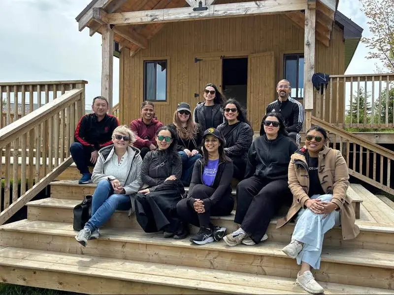Group of adults seated together on wooden cabin steps